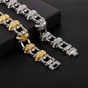 Detail of hip hop skull bracelets in silver and two-tone gold on black textured base