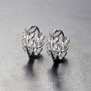 Detailed view of silver olive leaf hoop earrings with shimmering cubic zirconia