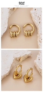 Detail view of gold-plated titanium steel earrings with heart and ring charms