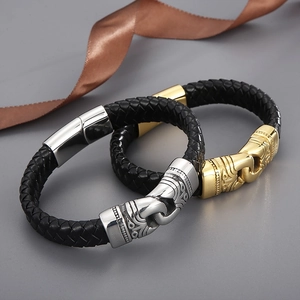 Macro detail of braided leather bracelets with engraved silver and gold buckles