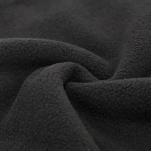 Macro shot showing the soft black fleece fabric texture of the winter warm hat and scarf
