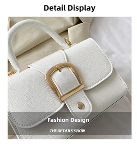 Detail of white lychee grain PU leather bag with large gold square buckle and strap