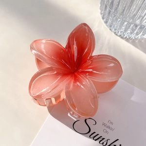 Close-up of translucent orange gradient flower hair claw clip with stable resin teeth