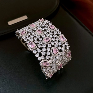 Detailed view of silver cuff bracelet with pink gemstones and pavé-set zircons
