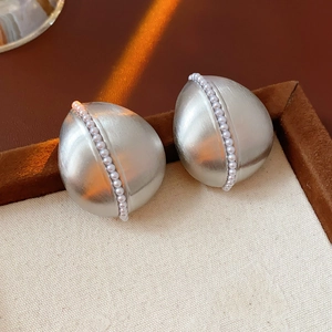 Close-up of silver drop earrings with pearl bead row in a luxury jewelry box