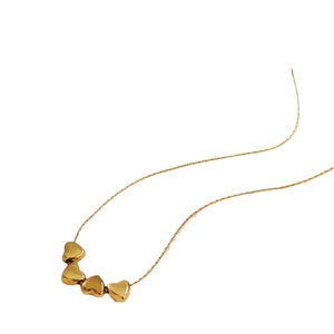 Elegant gold multi-heart pendant necklace with four connected charms on a thin chain