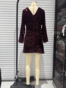 Detail view of burgundy sequined mini dress featuring long sleeves and deep V-back