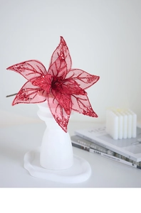 Macro detail of red glitter mesh poinsettia flower decoration in white vase