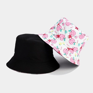 Detail of stacked reversible bucket hats in black and white fruit pattern prints