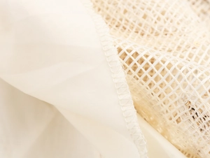 Macro shot of fine mesh sequins embroidery and beige fabric stitching detail