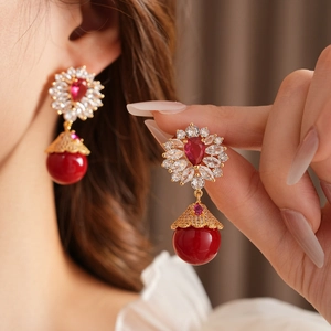 Gros plan de boucles d'oreilles vintage fleurs et pierres rouges sur un mannequin