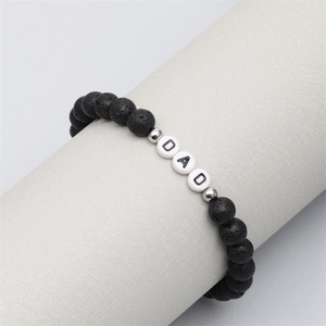 Detailed view of lava stone beads with DAD letters on a white leather wrist display