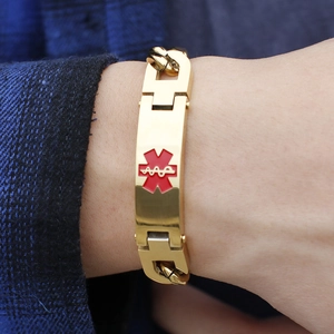 Close-up of golden medical alert bracelet with red Caduceus symbol worn on a male wrist