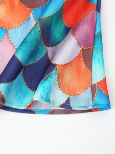 Detailed view of colorful mermaid scale print on the hem of a polyester maxi dress
