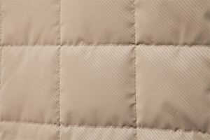 Macro view of khaki quilted fabric with high-density stitching for autumn men jacket