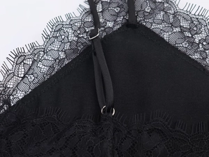 Detailed close-up of delicate eyelash lace trim and adjustable thin straps on a satin top