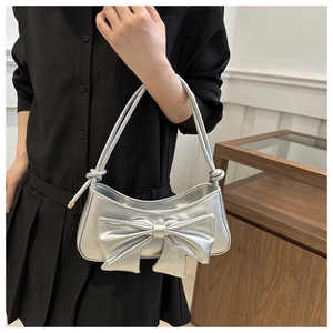 Silver bow shoulder bag with crocodile pattern and metallic finish on model