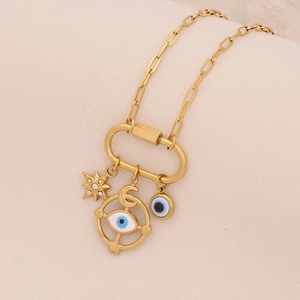 Detail of gold necklace with star, moon, and blue evil eye charms on a spring clasp