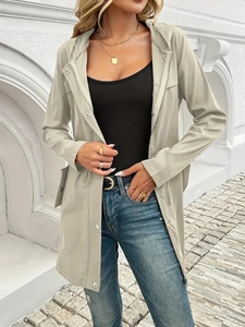 Detail of light beige utility jacket featuring adjustable drawstring waist and zipper