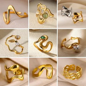 Minimalist adjustable wave rings with pearls and gemstones on beige silk background