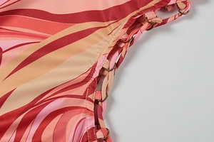 Detail of red and orange wave print dress with metallic eyelets and side lace-up tie