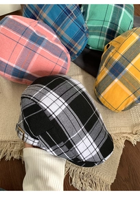 Gros plan de casquettes plates à carreaux rétro de diverses couleurs avec boucle en métal