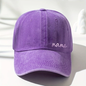 Detailed view of the purple washed baseball cap featuring pink 'mama' embroidery texture