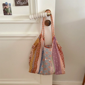 Detailed patchwork floral fabric texture and stitching of a large canvas tote bag