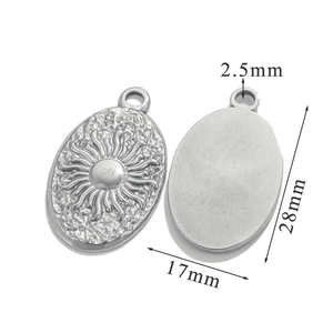 Detailed macro view of silver tarot sun pendant showing front relief and back texture