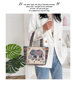 Ethnic canvas tote bag with colorful elephant embroidery held by a model in casual wear