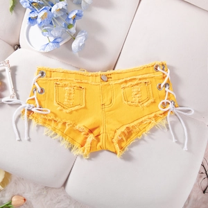 Dettaglio degli hot pants di jeans gialli con bordi sfrangiati e lacci laterali