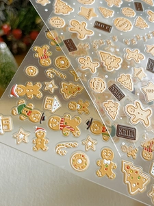 Macro detail of 3D embossed gingerbread man and Christmas tree nail art stickers