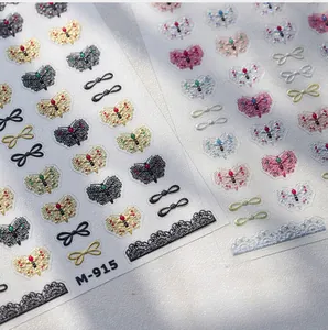 Macro detail of M-915 gold butterfly nail stickers with vintage black and colorful lace patterns