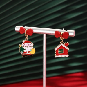 Detail of Santa Claus and red house earrings with bows on a silver display stand