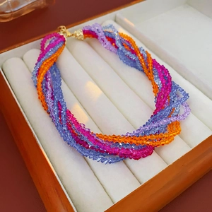 Detail of multi-strand twisted necklace with colorful faceted crystal beads and gold clasp