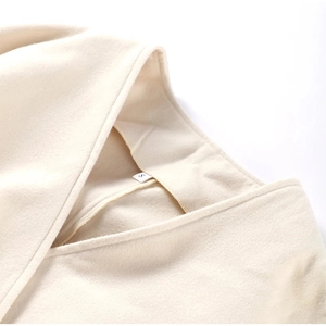 Detail of soft cream-colored V-neck jacket fabric texture with size S neck label