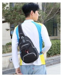 Outdoor shot of the men's black nylon crossbody bag featuring waterproof material