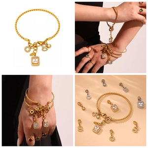 Detail of twisted gold bangle with detachable diamond charms and large square zircon