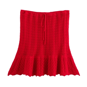 Dettaglio della minigonna rossa in maglia traforata con coulisse e bordo a balze