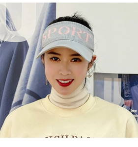 Close-up of light grey knit sun visor with pink 'SPORT' embroidery for athletic use