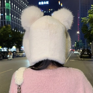 Rear view of a white faux fur winter hat with cute bear ears and fluffy pom-poms