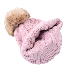 Pink cable knit winter beanie for women featuring a large brown faux fur pom-pom