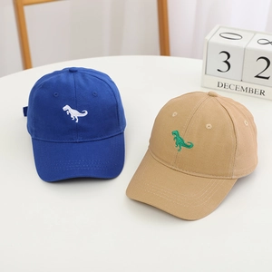 Détail de casquettes de baseball pour enfants bleues et kaki avec broderie dinosaure