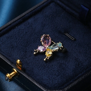 Elegant butterfly brooch with multicolored crystals on luxury dark blue velvet display