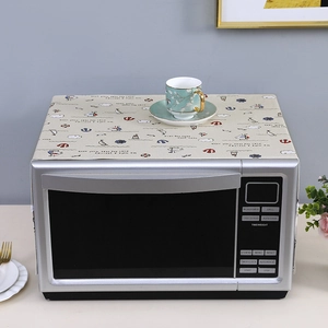 Close-up of linen microwave dust cover featuring blue nautical anchor and sailboat patterns