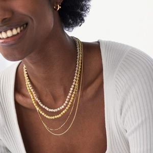 Layered natural stone beaded necklaces in lavender and yellow on model neck