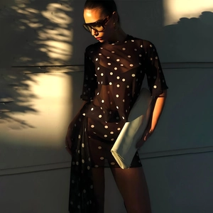 Chic black polka dot sheer dress with pleated tie details and artistic shadow effect