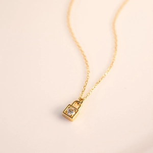 Detailed view of 18K gold-plated padlock pendant with sparkling zircon on fine chain