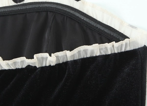 Vue détaillée du tissu en velours noir avec bordure en dentelle blanche à volants