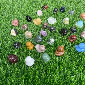 Variety of hand-carved crystal and gemstone ducks displayed on a natural grass background